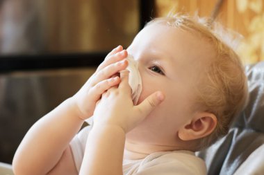 Çocuk burnunu beyaz mendille siler. Soğuk rhinitis 'li bir çocuk. Virüs ve enfeksiyon. Coronavirus belirtileri. yan görünüm