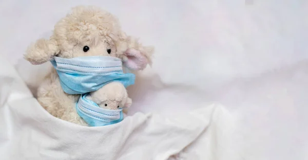 장난감 어미가 양고기를 침대에 아이들의 게임에서 의료용 마스크를 보호하기 장난감을 — 스톡 사진