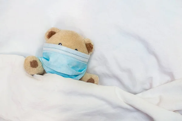 장난감 침대에 아이들의 게임에서 의료용 마스크를 보호하기 장난감을 합니다 코로나 — 스톡 사진