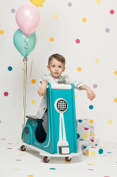 Boy on a toy motorcycle on a white background — Stock Photo, Image