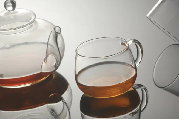 Bule de vidro transparente e xícara com chá — Fotografia de Stock