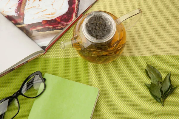 Té y un libro sobre un mantel verde — Foto de Stock