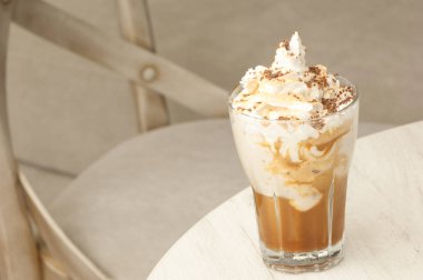 bir cam masanın üzerinde bir içkiyle