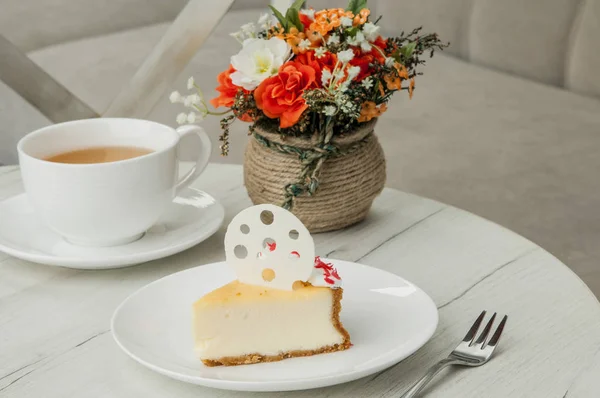 Pastel en un plato y una taza en la mesa — Foto de Stock