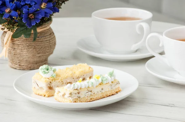 Pastel en un plato y una taza en la mesa — Foto de Stock