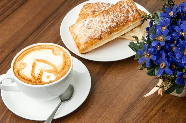 Brötchen und Tasse Kaffee auf dem Tisch — Stockfoto