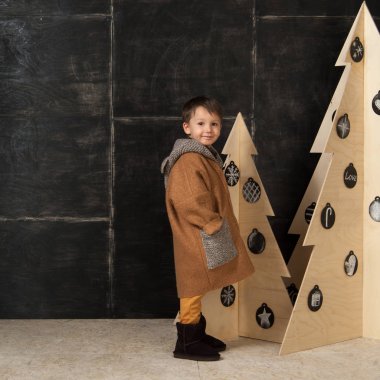 Dekoratif Noel ağaçları yanındaki küçük çocuk