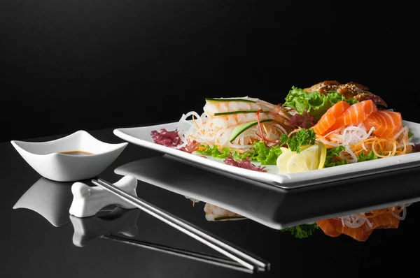 Sushi i en platta på en svart bakgrund — Stockfoto