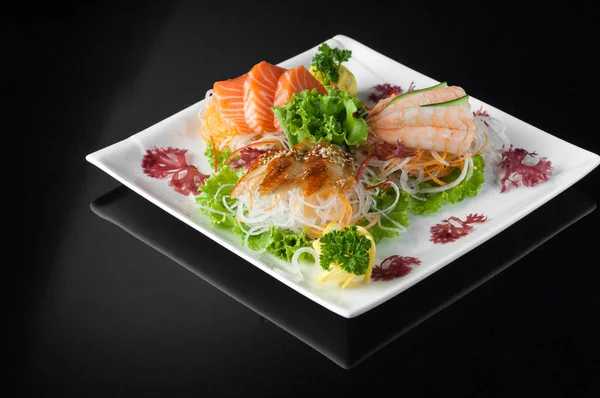Sushi i en platta på en svart bakgrund — Stockfoto