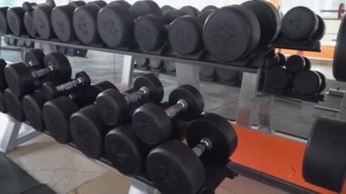 Modern bir spor salonunda bir sıra dambıl.