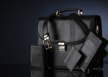 Koyu bir arka planda şık erkek aksesuarları. Çanta, cüzdan, kemer.