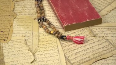 Kuran 'dan antik sayfalar taşıyan Müslüman dua boncukları. İslami ve Müslüman kavramları. Arap kitabından eski kâğıtlar. Büyütme efekti