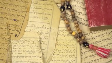 Kuran 'dan antik sayfalar taşıyan Müslüman dua boncukları. İslami ve Müslüman kavramları. Arap kitabından eski kâğıtlar.