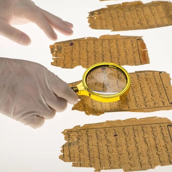 A researcher studies Arabic writing from the Koran using a magnifying glass and a table with a light. Paleography, the study of ancient Arabic writing