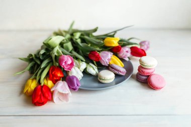 Bahar beyaz ahşap zemin üzerine macarons çiçekler