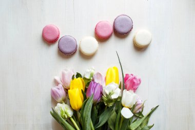 Bahar beyaz ahşap zemin üzerine macarons çiçekler