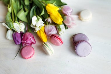 Bahar beyaz ahşap zemin üzerine macarons çiçekler