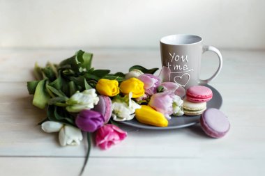 Bahar beyaz ahşap zemin üzerine macarons çiçekler