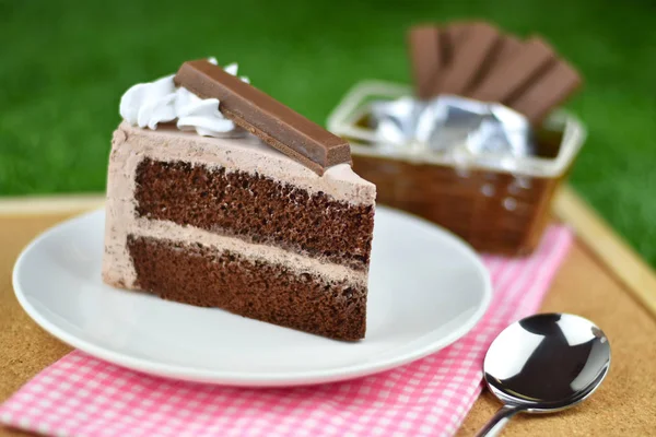 Chocolate cake with whip cream and chocolate wafer topping on gr — Stock Photo, Image