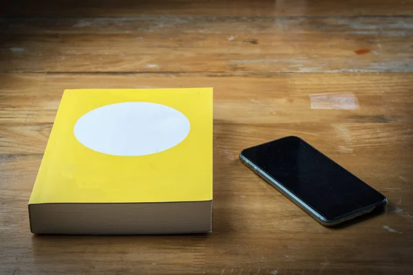 Książki z inteligentny telefon na drewnianym stole — Zdjęcie stockowe