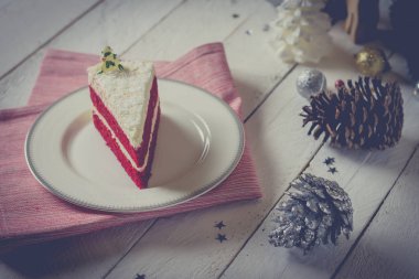 Kırmızı kadife kek beyaz masada beyaz krem dekorasyonu ile