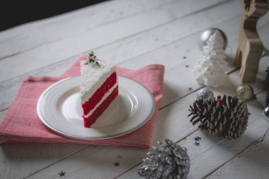 Kırmızı kadife kek beyaz masada beyaz krem dekorasyonu ile