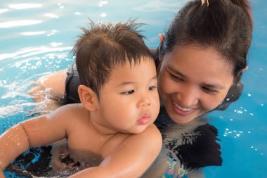 Genç neşeli anne ve küçük oğlu yüzme yüzmek içinde zevk