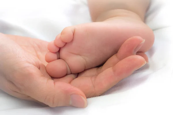 Close-up feet of baby in the hand of mother. — Stock Photo, Image