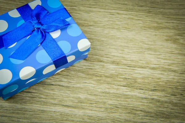 Beautiful blue gift with polka dots on a wooden background — Stock Photo, Image