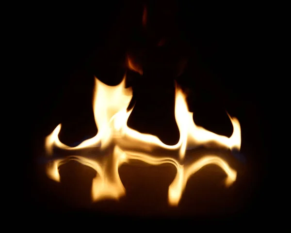 Flammes sur un fond noir avec réflexion miroir — Photo