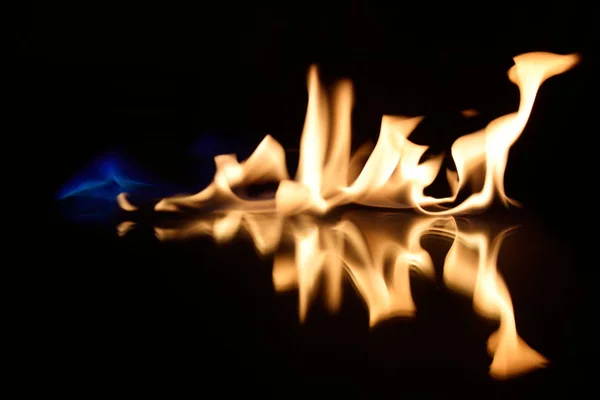 Flames on a black background with mirror reflection — Stock Photo, Image