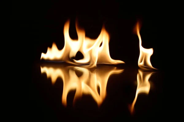 Flammen auf schwarzem Hintergrund mit Spiegelreflexion — Stockfoto