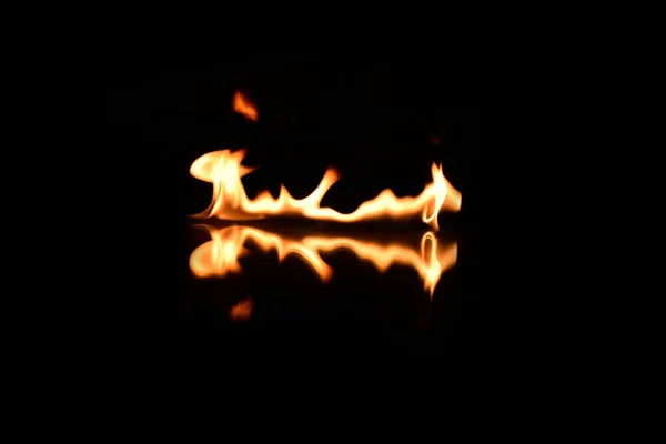 Flammes sur un fond noir avec réflexion miroir — Photo