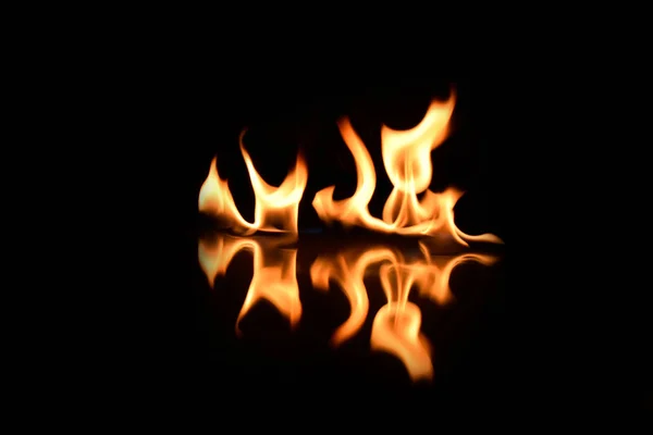 用镜子反射的黑色背景上的火焰 — 图库照片