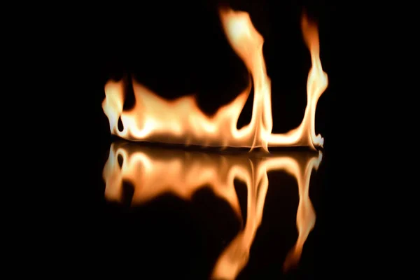 Fiamme su fondo nero con riflesso a specchio — Foto Stock