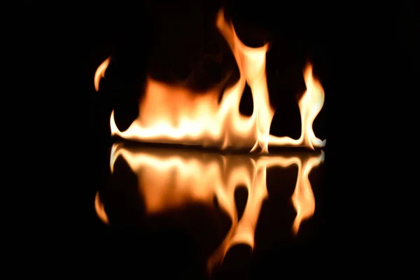 Flames on a black background with mirror reflection — Stock Photo, Image