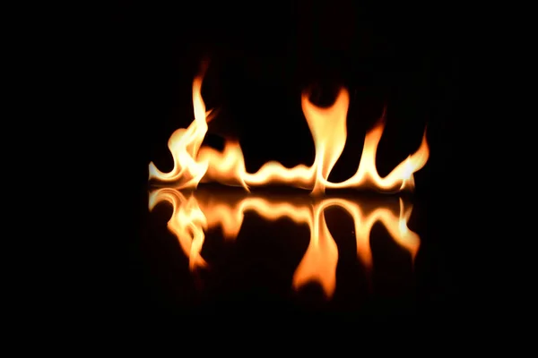 用镜子反射的黑色背景上的火焰 — 图库照片