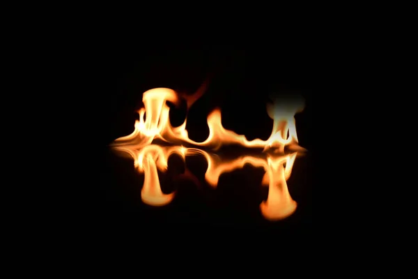 Flames on a black background with mirror reflection — Stock Photo, Image