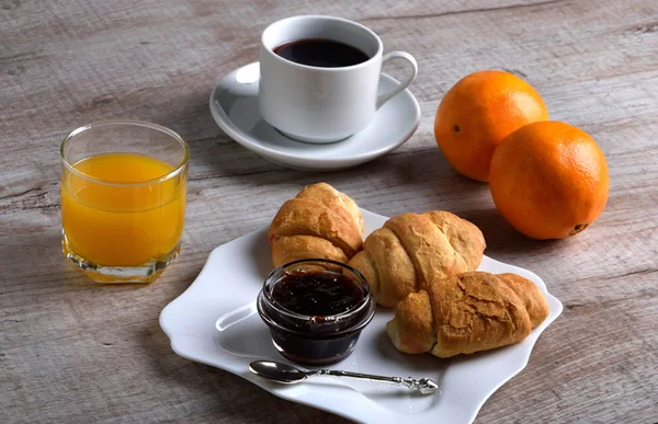 Легкий завтрак. сок и круассаны с джемом и чаем — стоковое фото