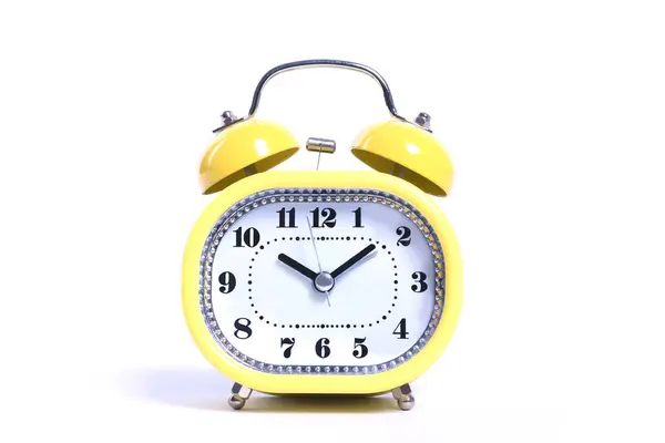 Yellow round oldfashioned glossy retro alarm clock isolated on white close up — Stockfoto