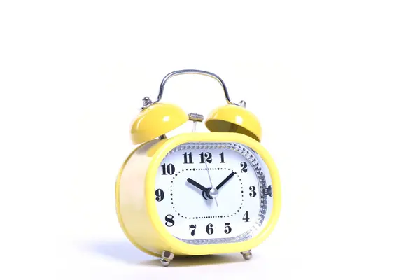 Yellow round oldfashioned glossy retro alarm clock isolated on white close up — Stockfoto