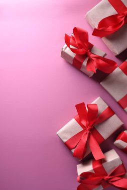 Valentines day background greeting card love symbols, red decoration with gifts boxes on pink background. Top view with copy space and text.Flat lay