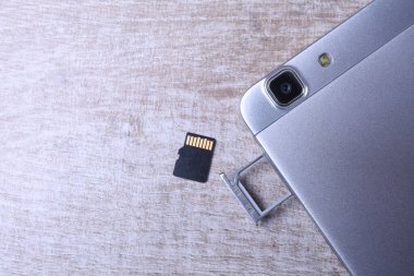 Flaş bellek depolama kavramı: Beyaz arkaplanda mikro Sd kartı olan bir tepsi. Taşınabilir elektronik cihazlarda dijital bilgi depolamak için bir hafıza kartı kullanılır. Örneğin cep telefonu, tablet vb.