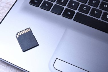 Tahta masadaki gri dizüstü bilgisayarda mikro Sd hafıza kartı adaptörü. Kapat.