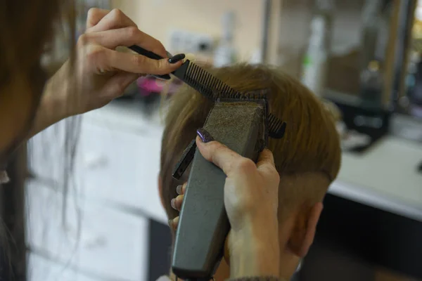 Парикмахерская. Мужчина стрижет волосы у парикмахера-стилиста в парикмахерской. Расческа с ножницами, клиппер крупным планом. Барбер на работе. Закрыть стрижку волос . — стоковое фото