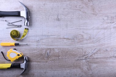 Çekiç demiri, santimetre bant ve tahta zeminde çiviler.