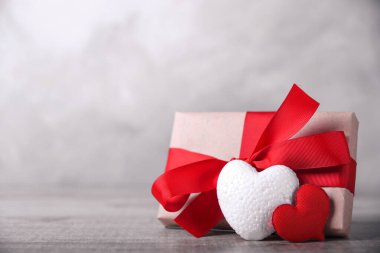 Tahtada kalpler ve hediye geçmişiyle Sevgililer Günü tebrik kartı. Tebrik mesajlarınız için boşluk ile