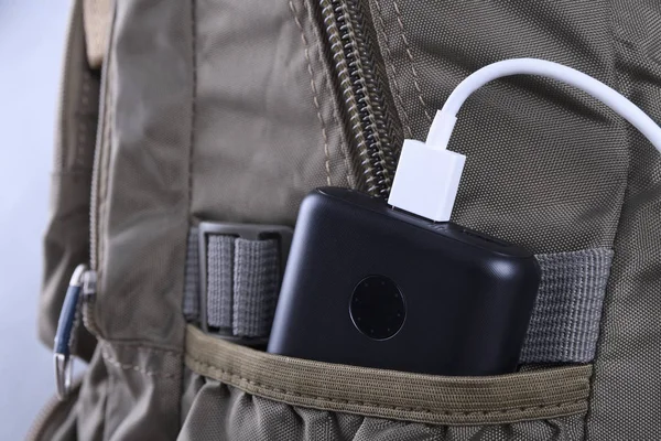 Telefon şarjı, elektrik faturası akıllı telefon, enerji bankasıyla cep telefonu. Sırt çantasındaki Güç Bankası alanının derinliği
