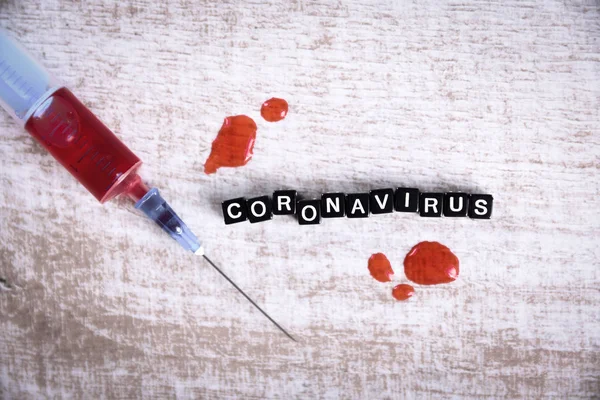 Coronavirus del concepto, coronavirus del síndrome respiratorio del Medio Oriente de MERS-Cov. Coronavirus originario de Wuhan, China.Inscripción. Jeringa y sangre en mesa de madera . — Foto de Stock