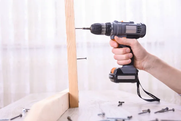 O homem está trabalhando com montagem de móveis usando chave de fenda elétrica na instalação de nova casa - trabalho técnico no local usando o conceito de ferramentas manuais — Fotografia de Stock